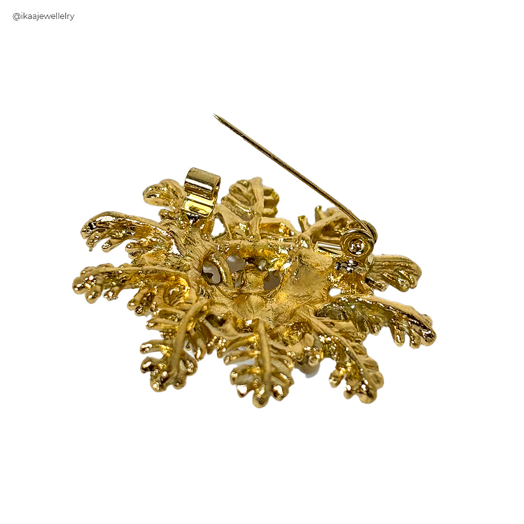A close-up of a silver Himani Saree Pin with intricate floral detailing, perfect for securing a traditional Indian garment.
