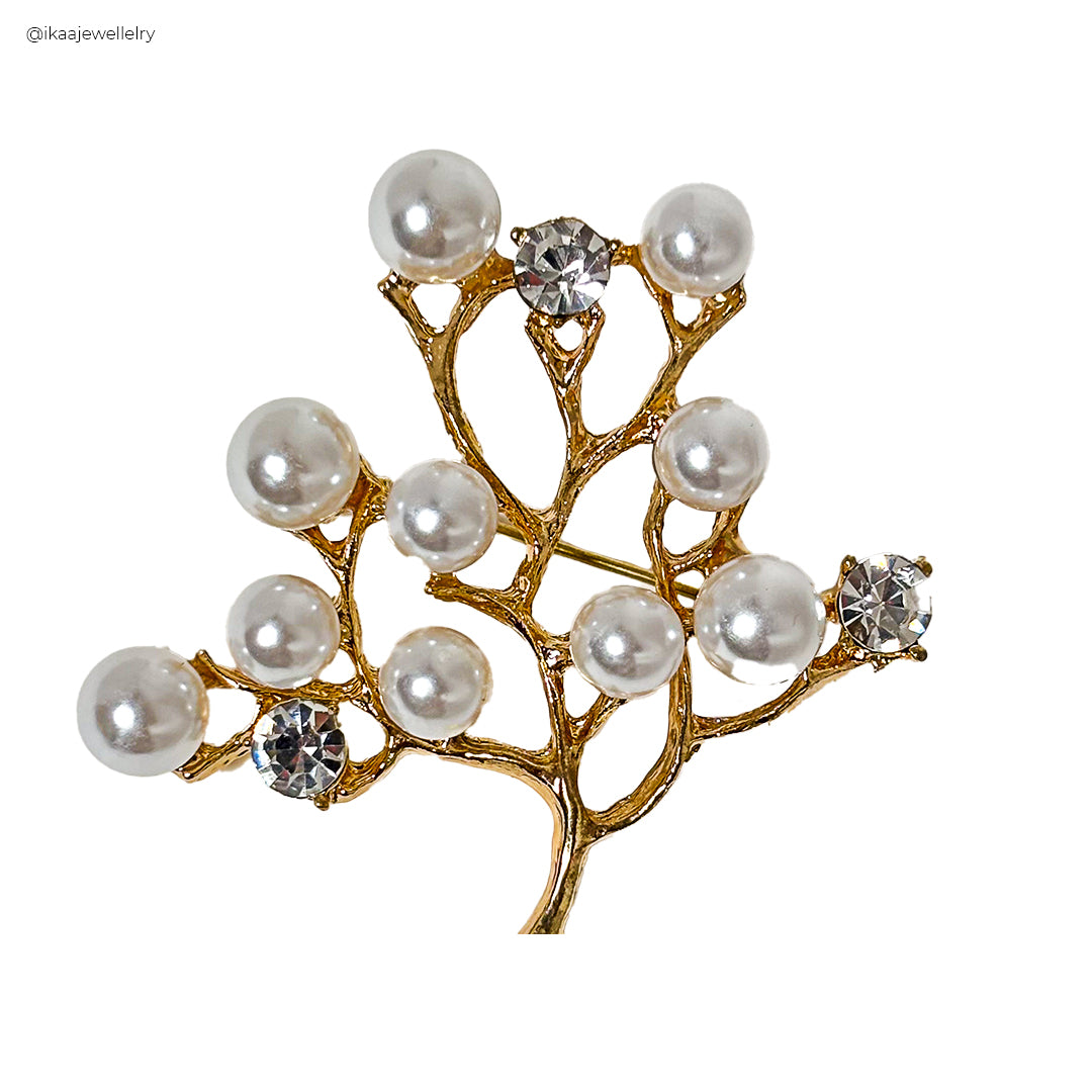 Close-up of the Vanya Saree Pin, a silver-toned brooch with intricate floral carvings and a central pearl accent.