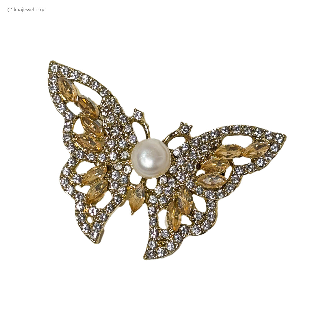 A gold Kanchan Saree Pin / Brooch with intricate floral and paisley designs, featuring a large central stone.