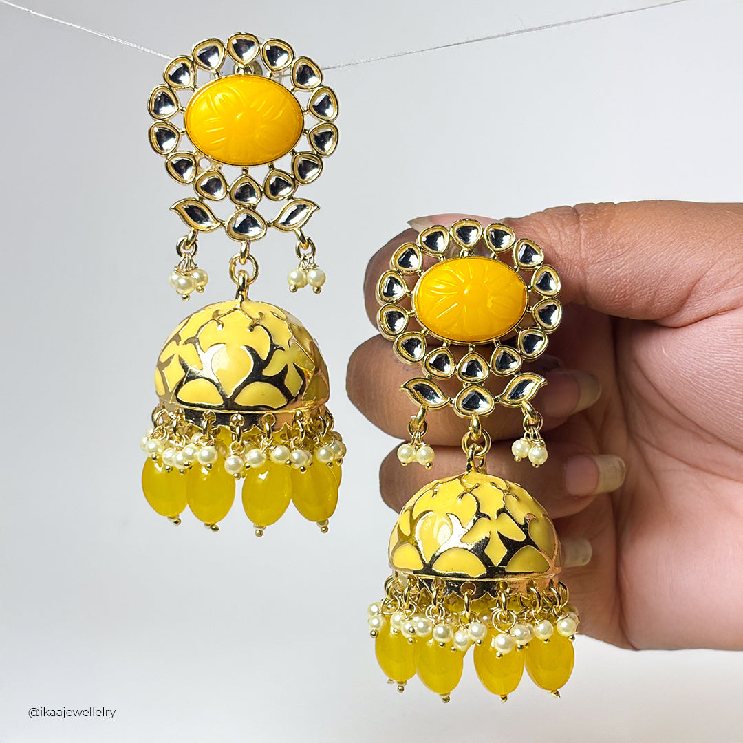Meira Jhumka Earrings: Elegant gold-toned jhumkas with intricate floral patterns and pearl drops.
