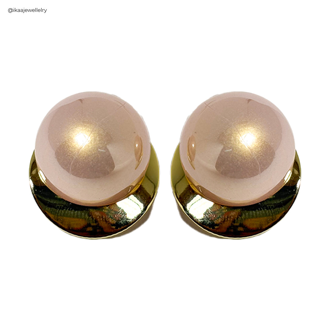Close-up of the Nuva Earrings, showcasing their delicate gold hoop design with a single pearl drop.