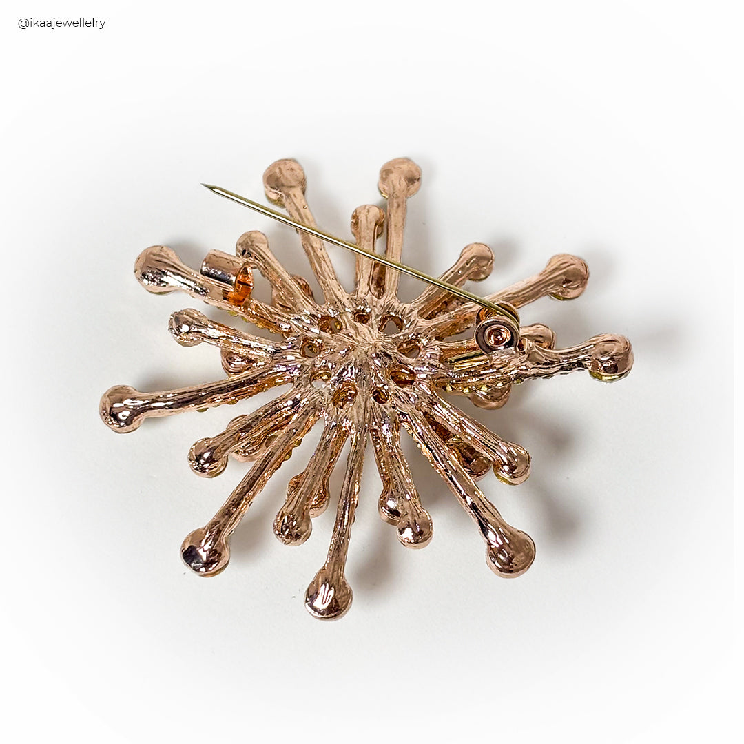 Close-up of the Gulnaar Saree Pin, a gold-toned accessory with intricate floral and leaf designs.