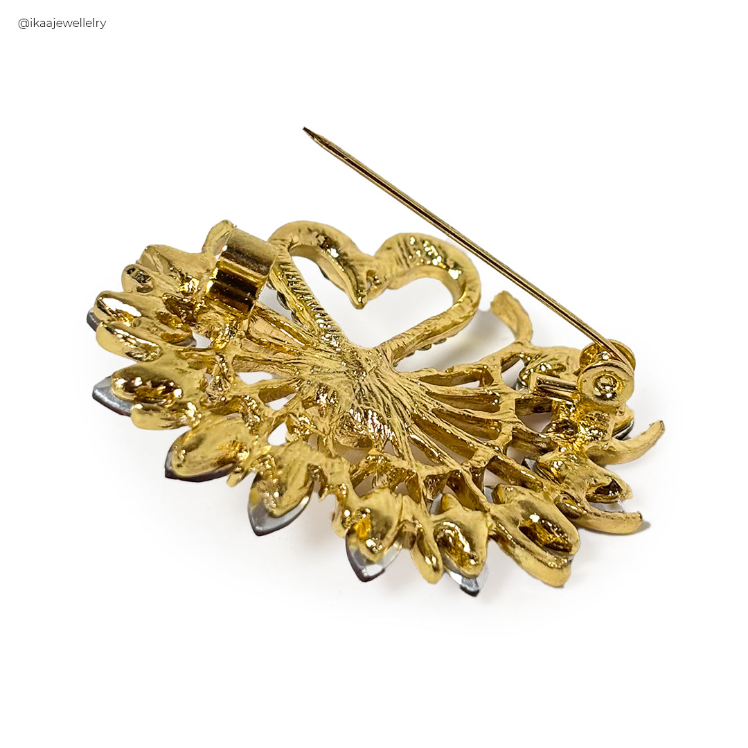 A close-up of the Hamsini Saree Pin, showcasing its intricate gold floral design with a sparkling stone accent.