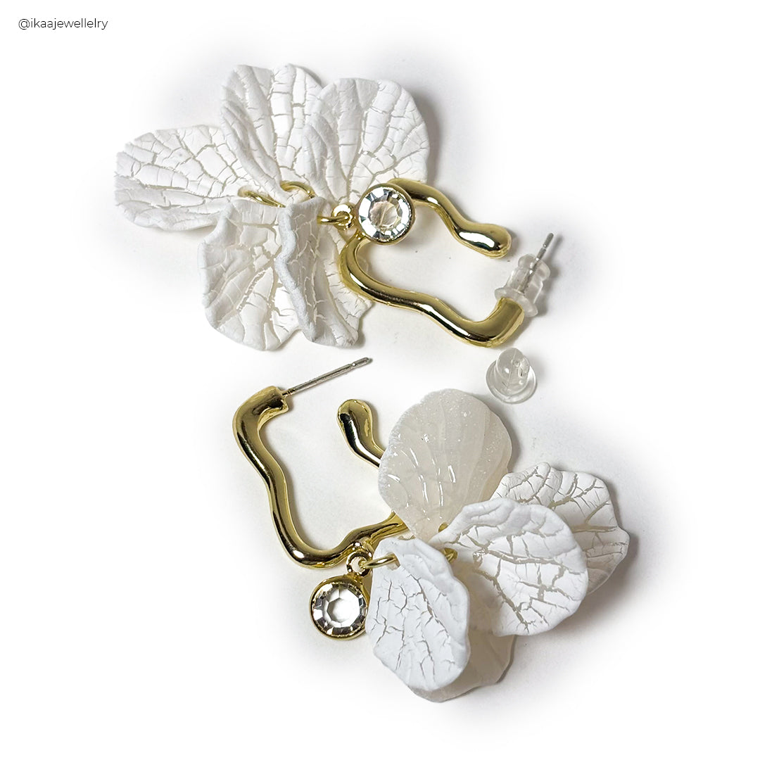 Close-up of Camia Earrings: delicate gold hoops with a single pearl drop, showcasing intricate craftsmanship and elegance.