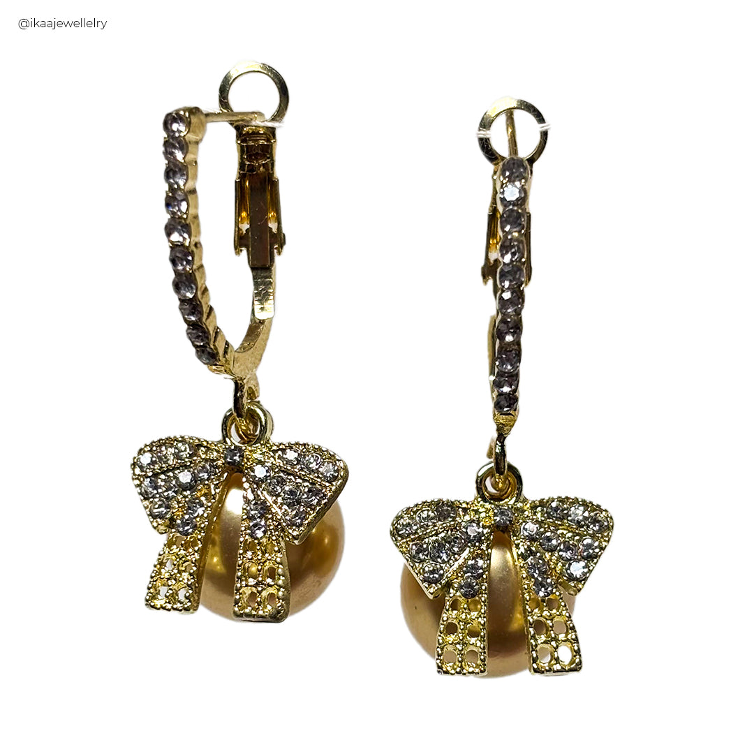 Orna Earrings: Close-up of two delicate gold drop earrings featuring intricate filigree designs, each with a small pearl