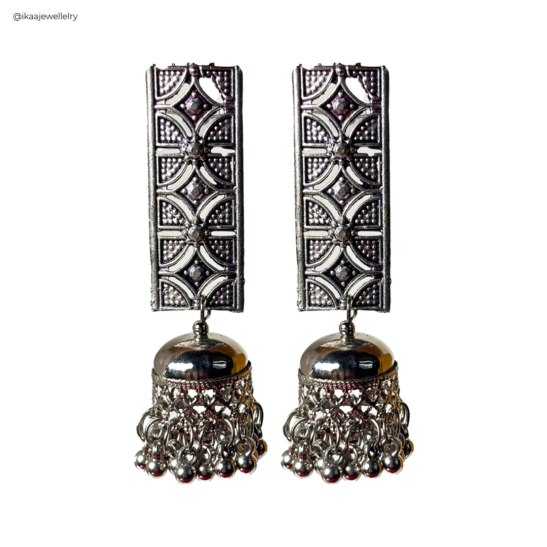 Janhavi Earrings: Close-up of intricate gold drop earrings with delicate pearl accents.