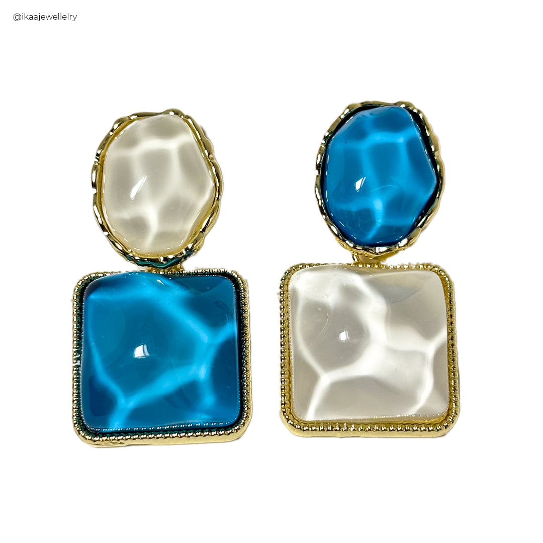 Close-up of the Mira Earrings, featuring delicate gold hoops with small pearl drops.
