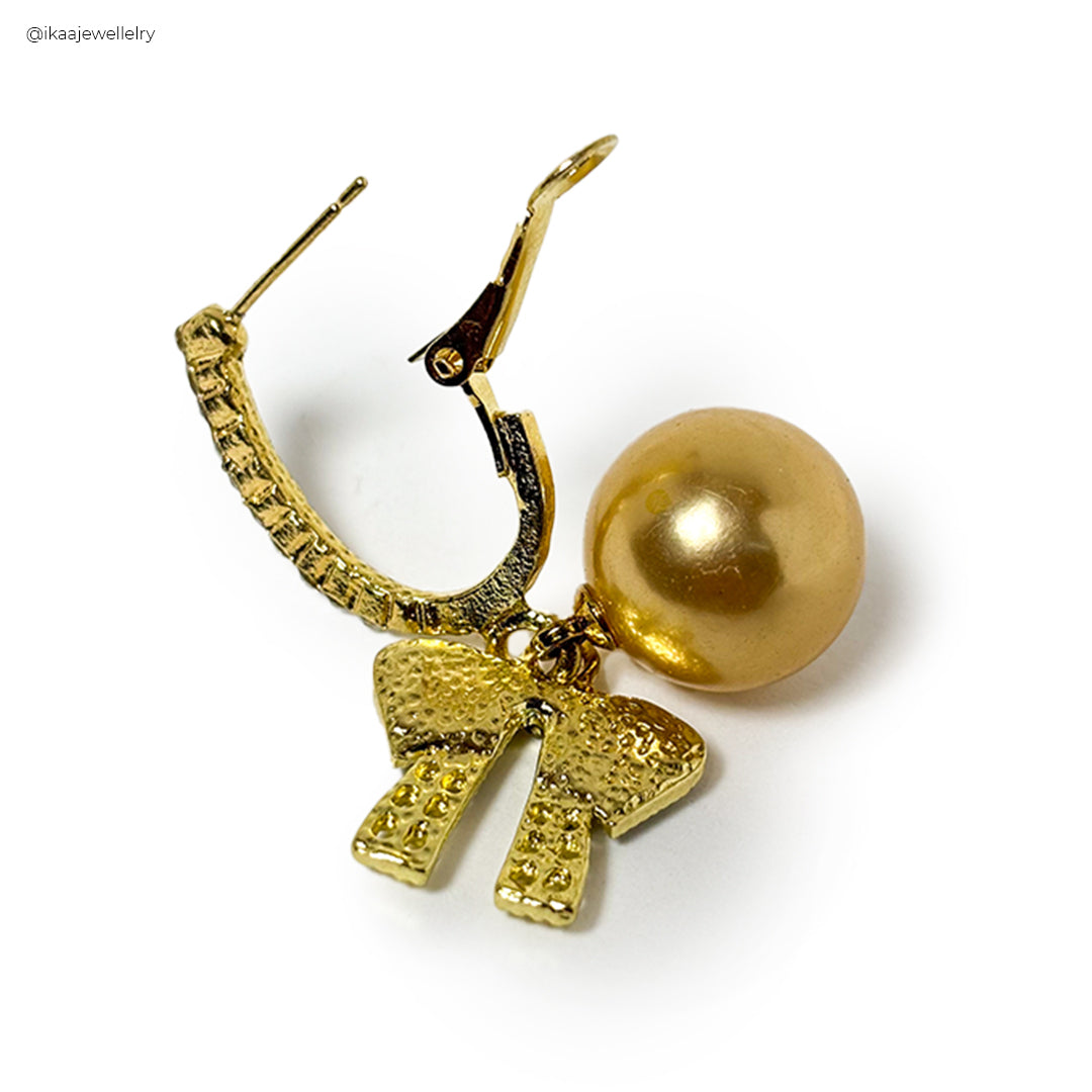 Orna Earrings: a pair of delicate gold drop earrings with pearl accents, displayed on a white background.