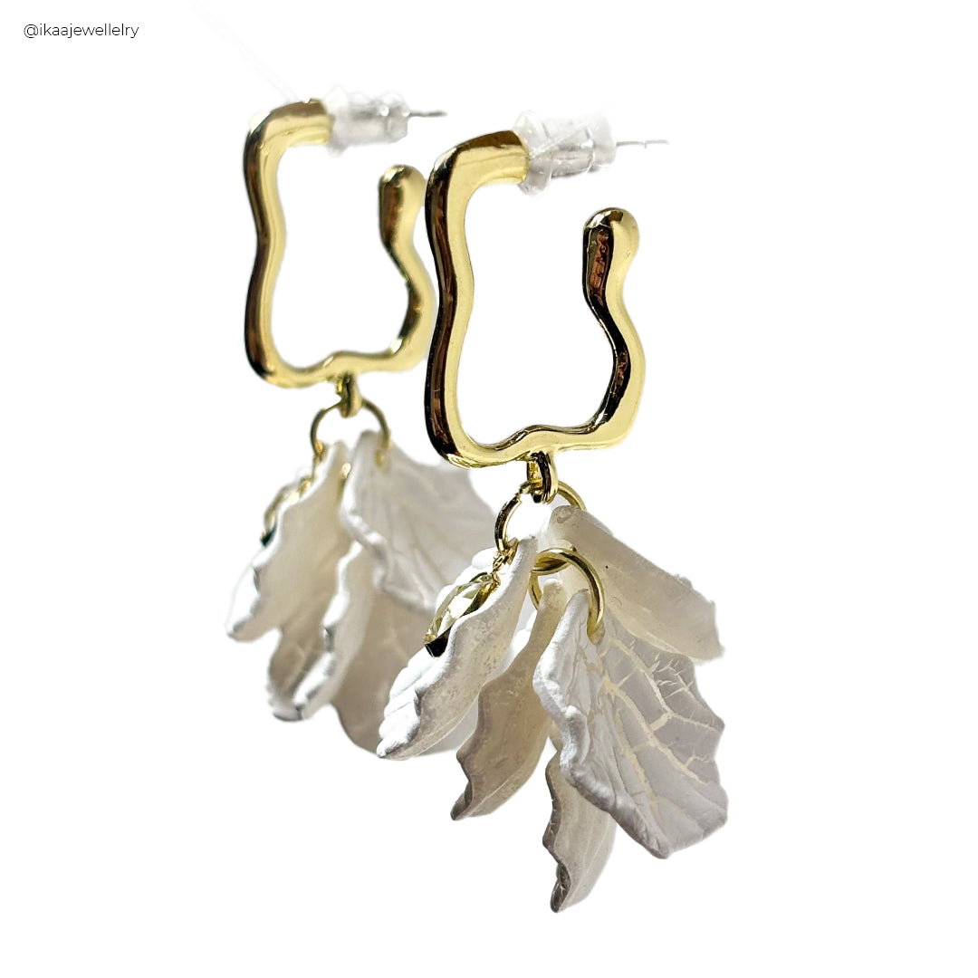 Close-up of Camia Earrings: delicate gold hoops with a single pearl drop, showcasing intricate craftsmanship.