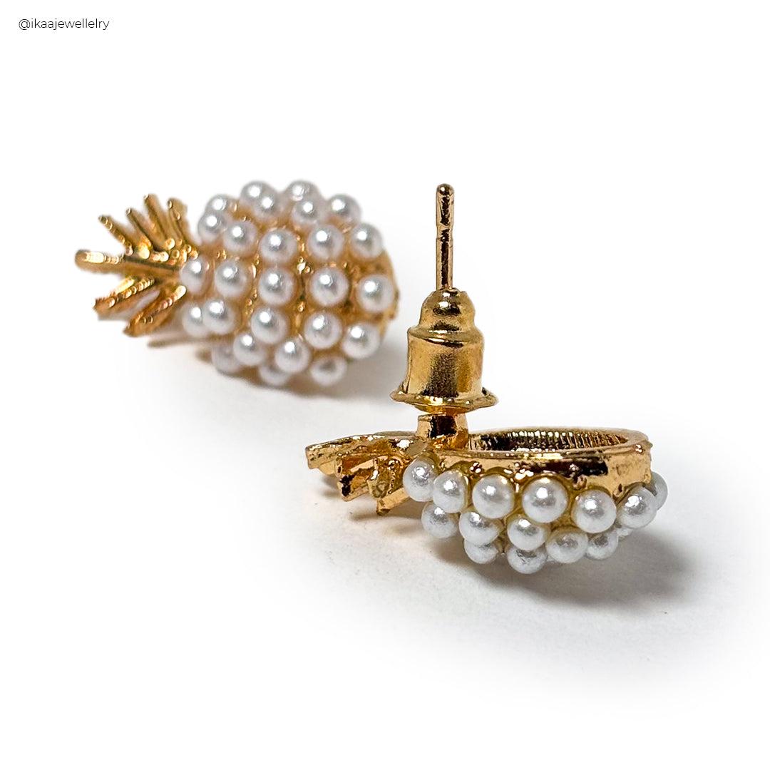 Close-up of elegant Pina Pearl Earrings featuring lustrous white pearls set in gold.