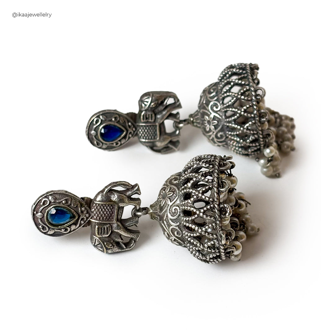 Close-up of Saumya Earrings: delicate gold-toned hoops with intricate pearl embellishments.
