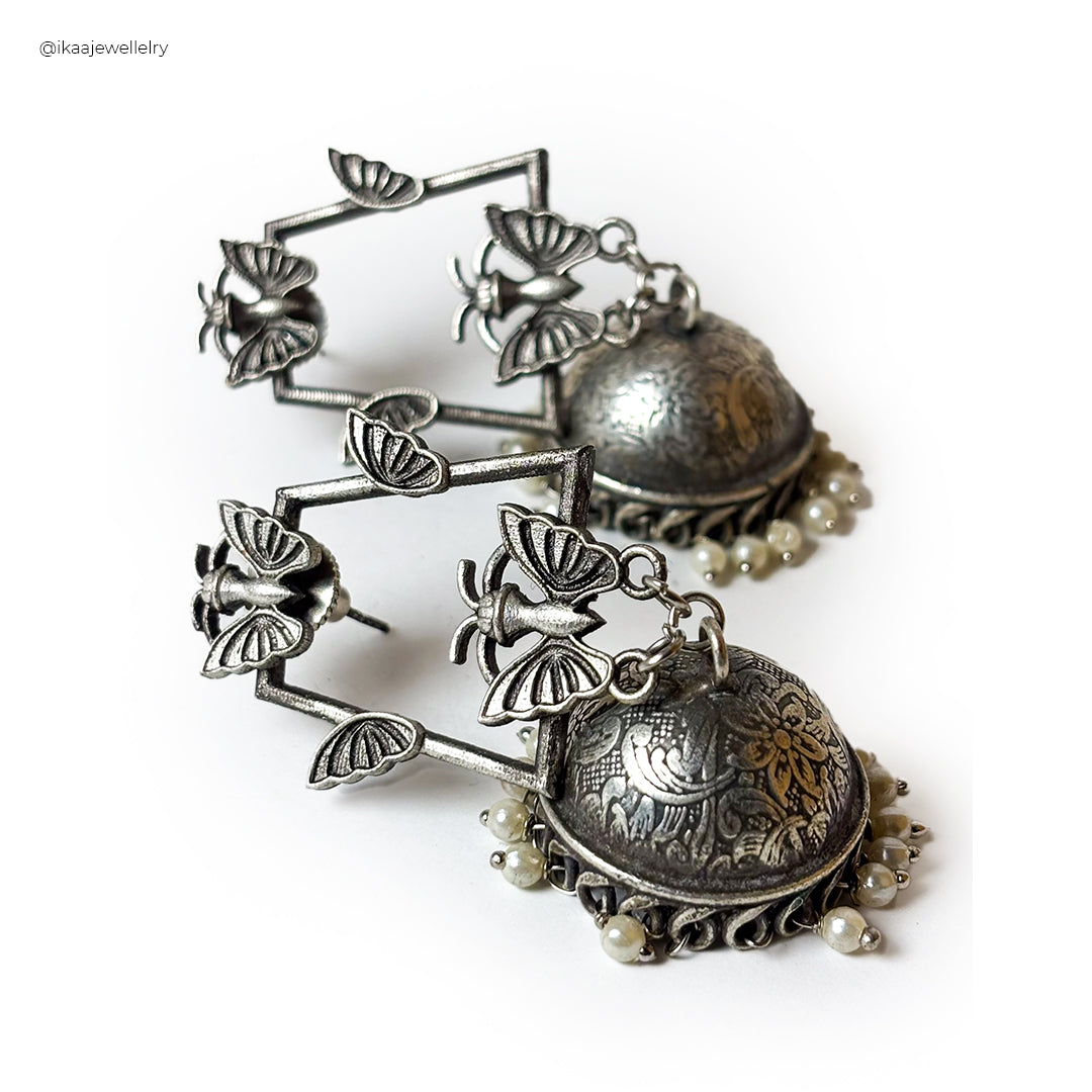 Close-up of the Siya Earrings, featuring delicate gold hoops with intricate floral detailing and small pearl accents.