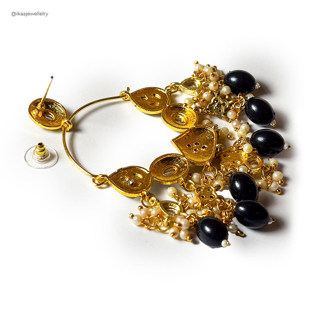 Close-up of Meghini Chandbali Earrings, intricate crescent-shaped gold earrings with pearl drops and red stone