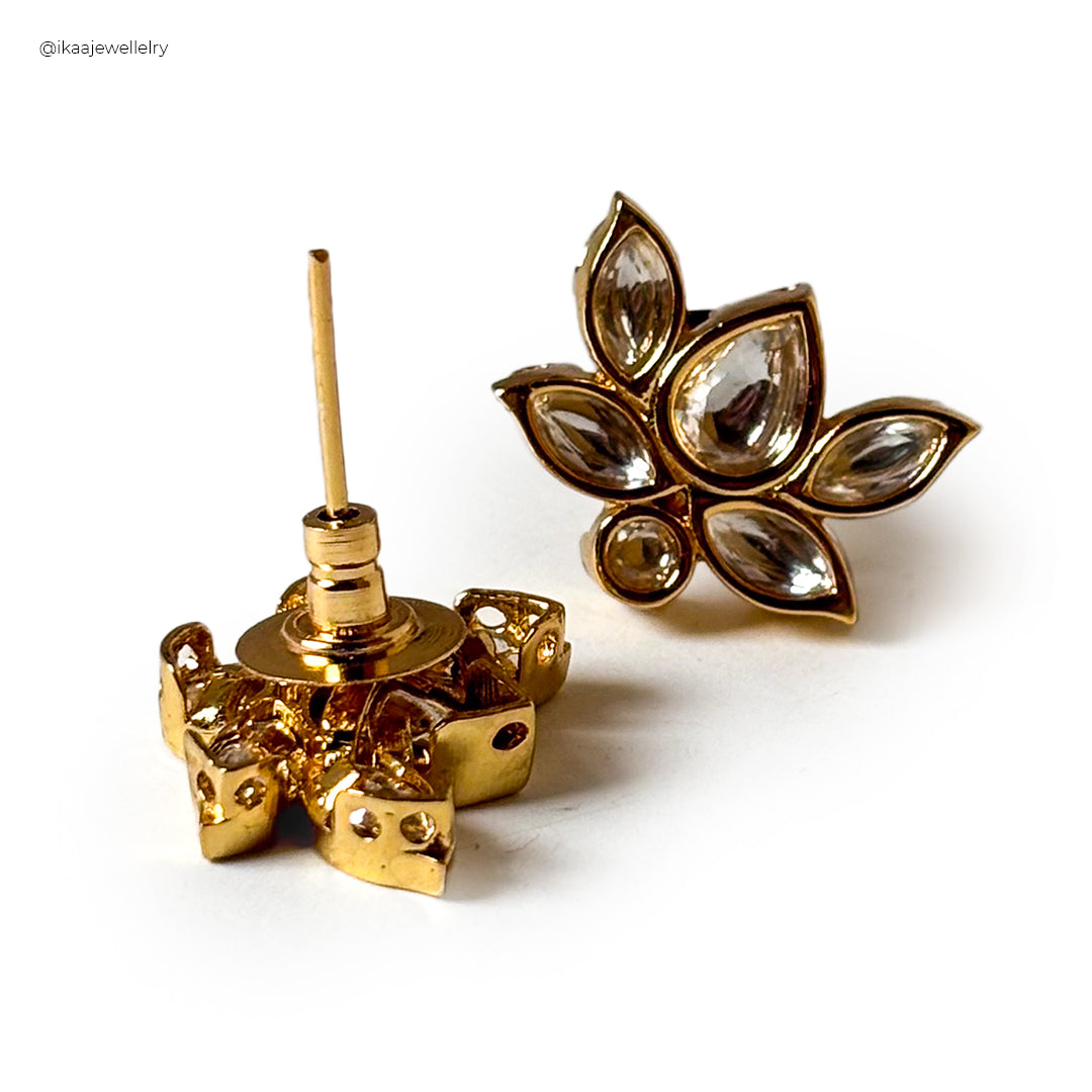 Close-up of Padma Earrings: delicate gold lotus flower studs with intricate petal details.