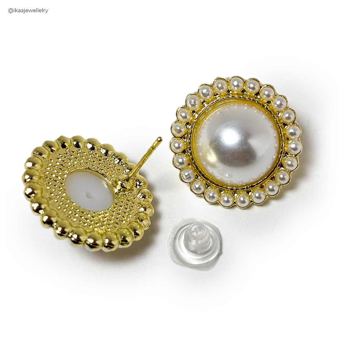 Close-up of the Misha Earrings: delicate gold hoops with a small, dangling pearl for an elegant look.