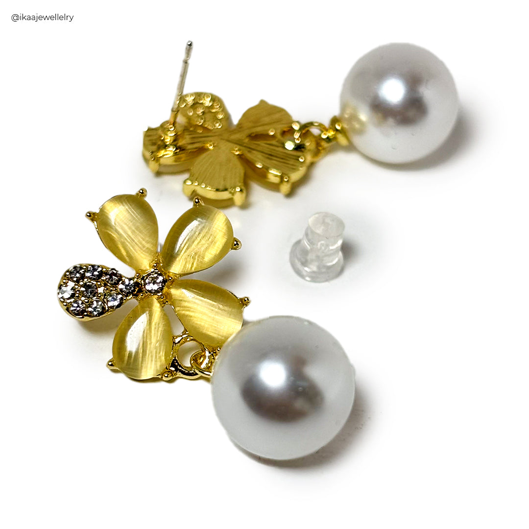 Close-up of delicate gold Kia earrings with intricate filigree detailing, showcasing their elegant design.