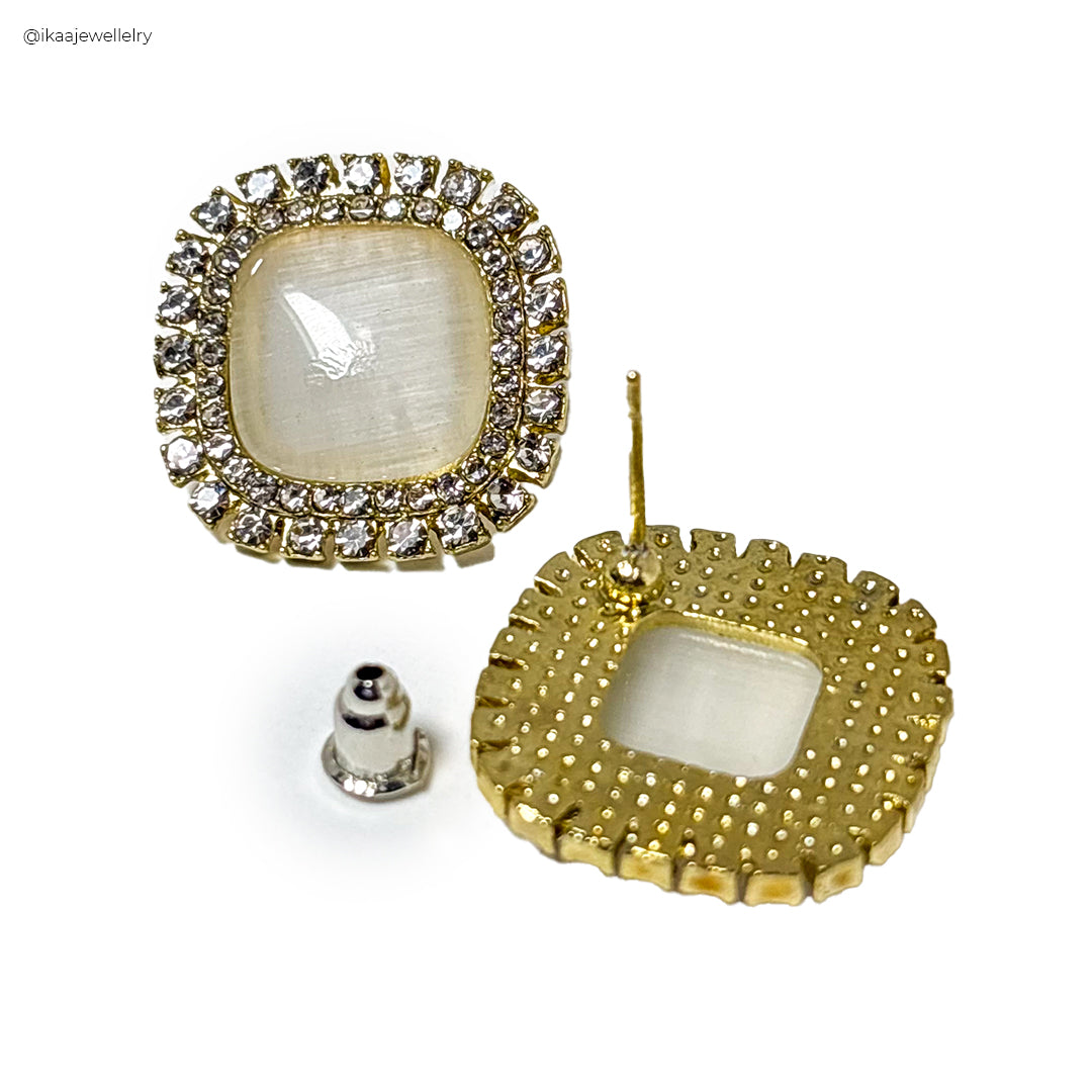 Niva Earrings: Close-up of two delicate gold hoop earrings with intricate hammered texture.