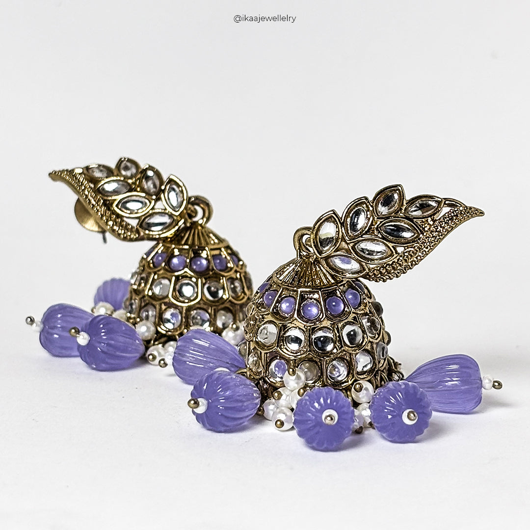 Malati Jhumka Earrings: Intricate gold-toned jhumka earrings with pearl and red bead embellishments, dangling from a