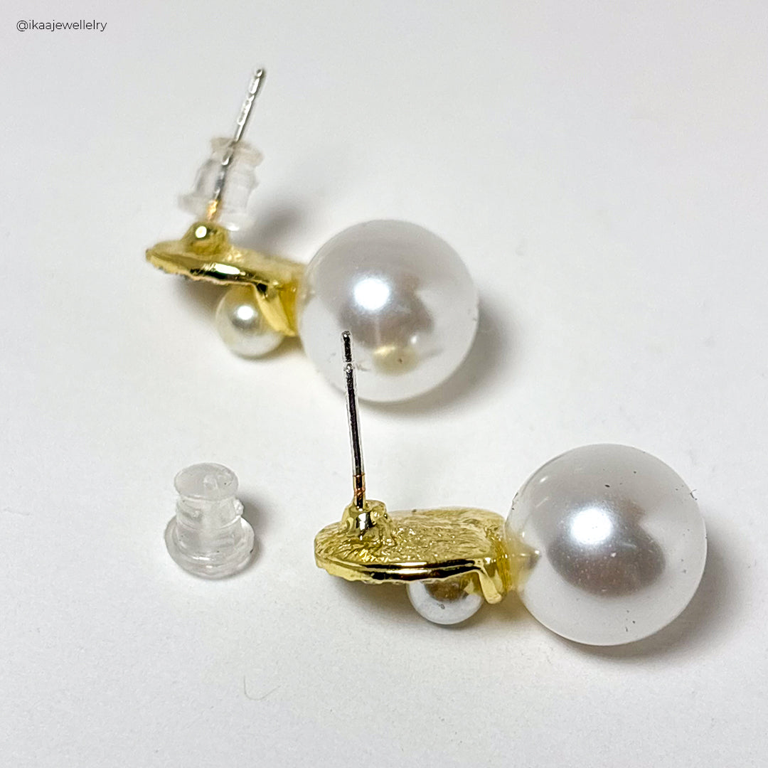 Saisha Pearl Earring: a single, lustrous white pearl dangles from a delicate gold chain, showcasing elegance.