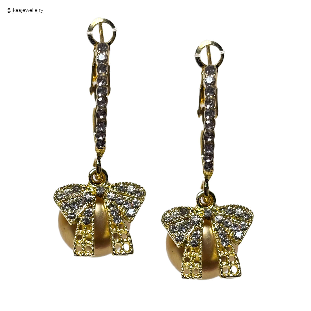 Orna Earrings: Close-up of delicate, hammered gold drop earrings with a subtle, organic texture.