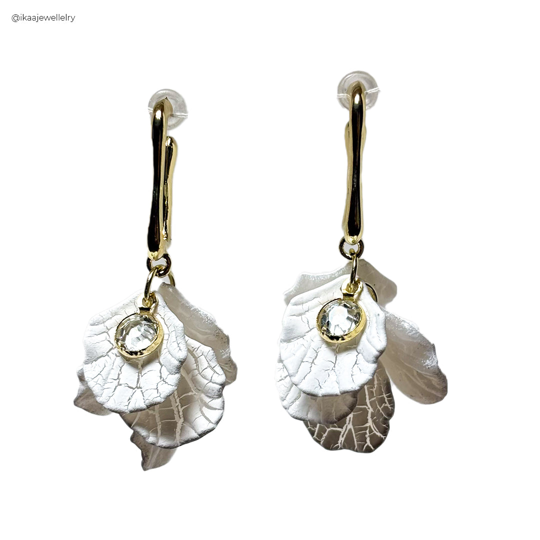 Camia Earrings: A close-up of delicate gold hoop earrings with a subtle hammered texture.