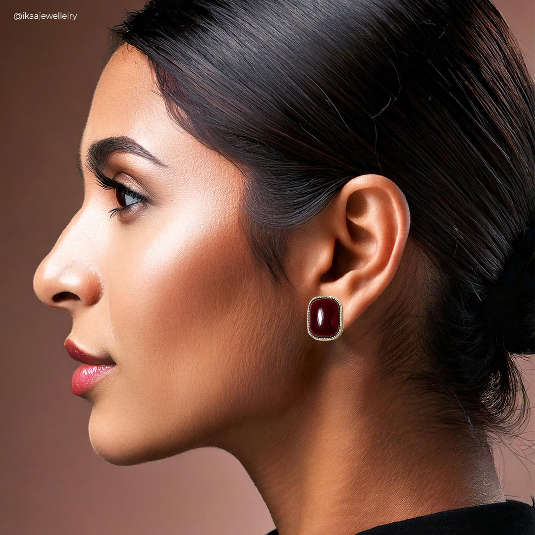 Close-up of the Rhea Earrings: delicate gold hoops with a single pearl drop.